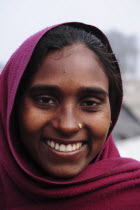 India, Uttarakhand, Hardiwar, Head and shoulders portrait of smiling young woman.