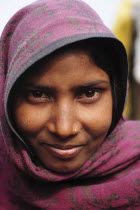 India, Uttarakhand, Hardiwar, Head and shoulders portrait of smiling young woman.