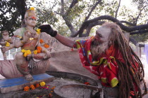 India, Uttarakhand, Hardiwar, Saddhu makes offering at shrine during Kumbh Mela, Indias biggest religious festival where many different traditions of Hinduism come together to bathe in the Ganges.