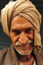 India, Uttarakhand, Hardiwar, Head and shoulders portrait of man wearing turban of brown cloth.