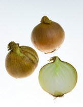 Food, Vegetables, Onions, Three ripe harvested onion bulbs or Allium against a white background with one sliced open to show structure of layers.