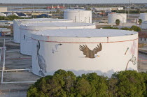 USA, Florida, Tampa, An attempt to put an environment friendly face on oil storage tanks along Maritime Boulevard.