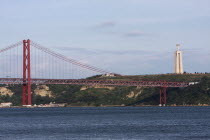 Portugal, Estremadura, Lisbon, 25th April Bridge over the Tejo River with the Christo Rei statue in the background.