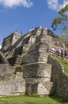 Belize, Altun Ha, The Temple of Masonry Altars in Plaza B of the Mayan ruins, A large carved jade head of the Mayan sun god Kinich Ahau was found in the temple, Tourists climbing stairway and atop the...