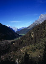 Switzerland, Bern, Gadmertal, View west along Gadmertal valley over the Lower Susten Pass road with Tallistock at 2580 metres on skyline at right and tree covered lower slopes.