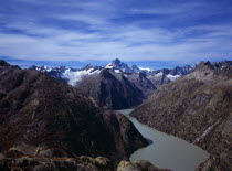 Switzerland, Bern, Grimselsee, Glacial lake viewed from the east above the Grimsel Pass. Peak of Finsteraarhorn partly covered in snow at centre on skyline 4274 metres.