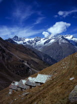 Switzerland, Zermatt, Weisshorn mountain 4506 metres with shepherd huts in foreground used for storage and shelter for climbers.