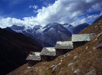 Switzerland, Zermatt, Weisshorn mountain 4506 metres with shepherd huts in foreground used for storage and shelter for climbers.