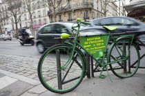 France, Ile de France, Paris, denfert Rochereau, Green bicycle, padlocked against railings, advertising Boutique de L'Ecologie.