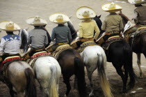 Mexico, Bajio, Zacatecas, Traditional horsemen or Charros  standing, mounted, in line watching the competition at Mexican rodeo.