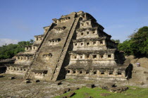 Mexico, Veracruz, Papantla, El Tajin archaeological site, Pyramide de los Nichos with tourist couple in middle foreground.