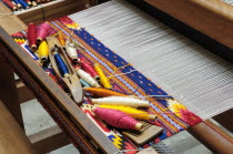 Mexico, Oaxaca, Spools of coloured wools on loom ready for weaving.