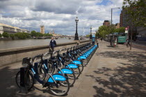 England, London, Vauxhall, Albert Embankment of the river Thames, man buying time on bicycle hire self service machine.