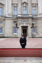 England, London, Westminster, Buckingham Palace exterior with Police guard at the entrance.