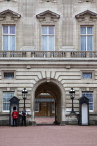 England, London, Westminster, Buckingham Palace exterior with both Queens Guard and Metropolitan Police armed officers.