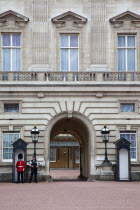 England, London, Westminster, Buckingham Palace exterior with both Queens Guard and Metropolitan Police armed officers.