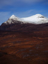 Scotland, Highlands, Coigach, Drumrunie Forest.  Twin peaks of Culmor at 849 metres with the upper reaches covered in snow.  View from Knockan Crag.