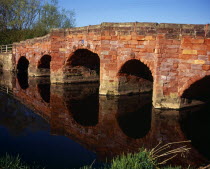 England, Hereford and Worcester, Eckington, Bridge on the B4080 crossing the River Avon and constructed from sandstone blocks, reflected in the river below.