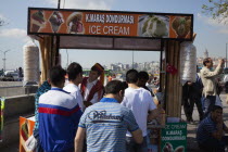 Turkey, Istanbul, Eminonu, Ice cream vendor outside the New Mosque with young men waiting to be served.