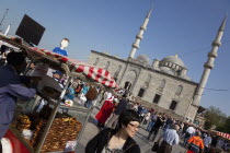 Turkey, Istanbul, Eminonu, Yeni Camii, New Mosque with pretzel vendor in the square.