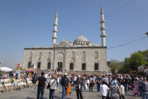 Turkey, Istanbul, Eminonu, Yeni Camii, New Mosque with people selling goods to the tourists in the square outside.