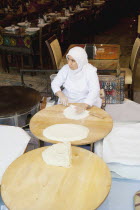Turkey, Istanbul, Sultanahmet, woman rolling out bread dough in restaurant.