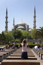 Turkey, Istanbul, Sultanahmet Camii, Blue Mosque, with tourist taking picture on her camera phone.