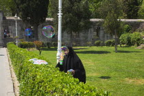 Turkey, Istanbul, Sultanahmet, woman selling bubvble gun machine in park outside the Blue Mosque.