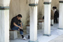 Turkey, Istanbul, Sultanahmet Camii, Blue Mosque, man preparing to wash feet before worship.