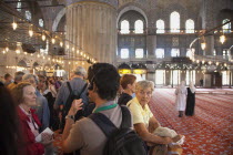Turkey, Istanbul, Sultanahmet Camii, Blue Mosque interior with guided tour group listening on headphones to guie.