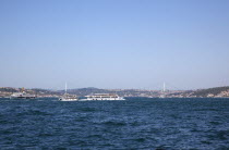 Turkey, Istanbul, Eminonu, view of the Bosphorus bridge with ferries passing in the foreground.