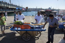 Turkey, Istanbul, Karakoy, Galata fish market, man selling freshly grilled fish served in a bread roll.