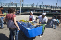 Turkey, Istanbul, Karakoy, Galata fish market, man selling freshly grilled fish served in a bread roll.