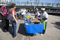 Turkey, Istanbul, Karakoy, Galata fish market, man selling freshly grilled fish served in a bread roll.