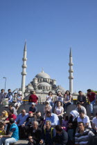 Turkey, Istanbul, Eminonu, Yeni Camii, New Mosque, people on sat on steps next to the subway.