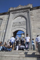 Turkey, Istanbul, Eminonu, Yeni Camii, New Mosque, people on steps by the entrance.