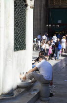 Turkey, Istanbul, Eminonu, Yeni Camii, New Mosque, worshippers washing feet in courtyard.