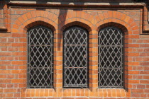 England, West Sussex, Arundel, detail of red brick building with lead light windows.