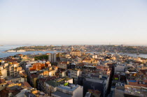 Turkey, Istanbul, View from Beyoglu across rooftops to Galata Tower and Golden Horn with Galata Bridge leadingto Sultanahmet with Haghia Sophia, New Mosque and Blue Mosque with Sea of Marmara beyond.