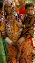 India, Karnataka, Lambani Gypsy woman holding child. Tribal forest dwellers, now settled in 30-home rural hamlets. Related to the Rabaris gypsies of Kutch, Gujarat.