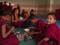 India, Sikkim, Young Buddhist student monks playing snakes and ladders.
