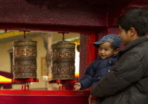 India, Sikkim, Devotees turning prayer wheels at a Buddhist Monastery.