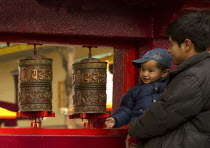 India, Sikkim, Devotees turning prayer wheels at a Buddhist Monastery.