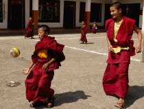 India, Sikkim, Buddhist student monks playing soccer at a monastery.