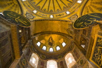 Turkey, Istanbul, Sultanahmet, Haghia Sophia with apse mosaic of Theotokos or Virgin Mary enthroned holding the baby Jesus Christ below the dome and Arab Muslim texts on Calligraphic Roundels on the w...