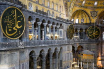 Turkey, Istanbul, Sultanahmet, Haghia Sophia North Gallery beside the Nave with sightseeing tourists and Arab Muslim text on calligraphic roundels on the walls with the Lodge of The Sultan below.