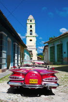 Cuba, Sancti Spiritus, Trinidad, Red 1957 Chevrolet convertible car parked in cobbled street.