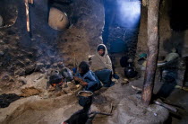 Ethiopia, Inside a rural house with women cookinfg by open fire fueled by animal dung.