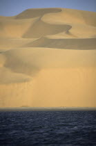 Namibia, Namib Naukluft Desert, sand dunes of the Langevaan a 1000 foot high wall of sand where the desert meets the Atlantic ocean.  Access is restricted due to Diamond mining activity by DeBeers.