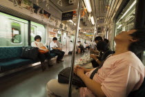 Japan, Honshu, Tokyo, commuters asleep on train.